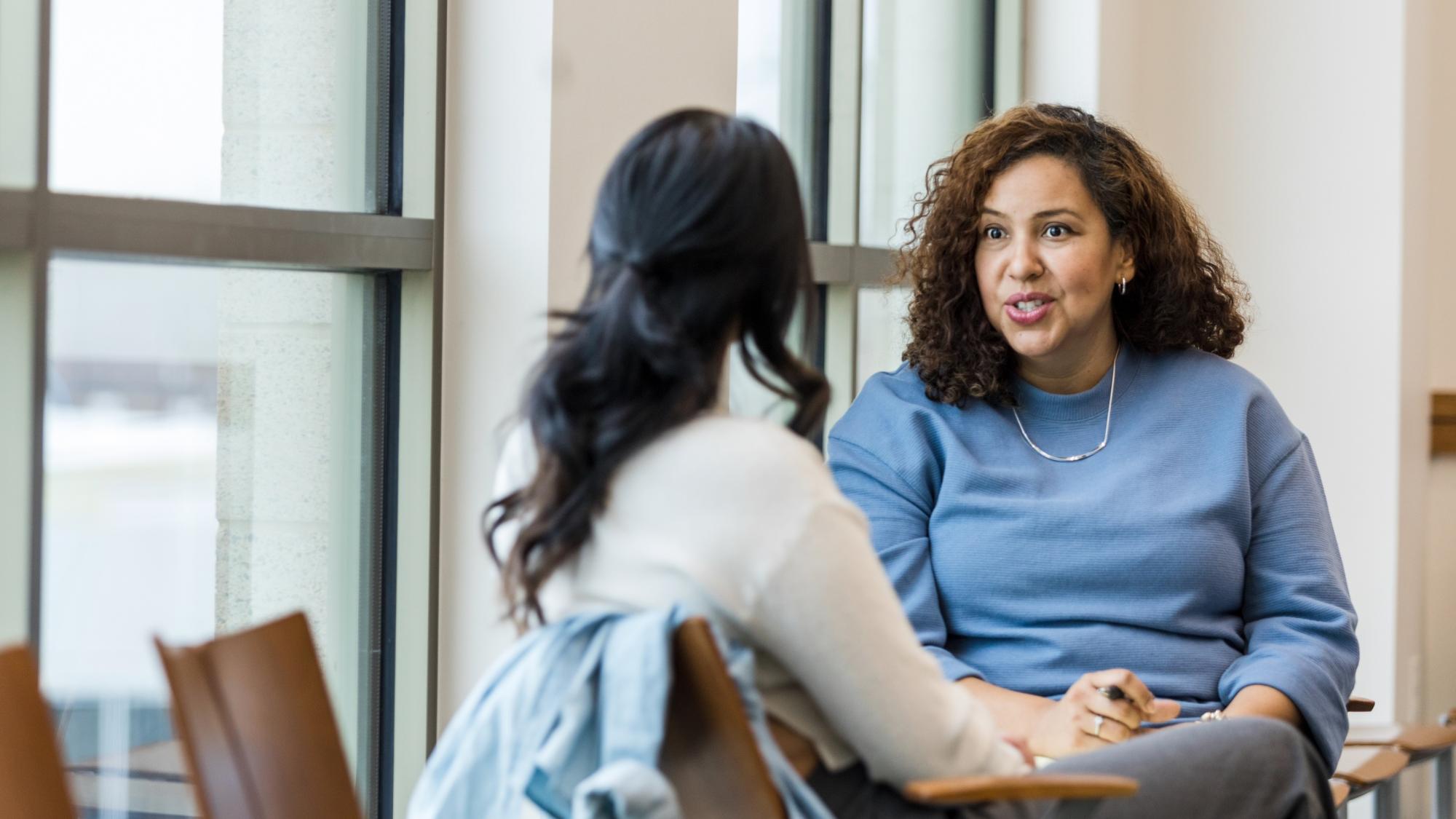 Supervisor meets with mid adult female employee to mentor her regarding a new position she is interested in