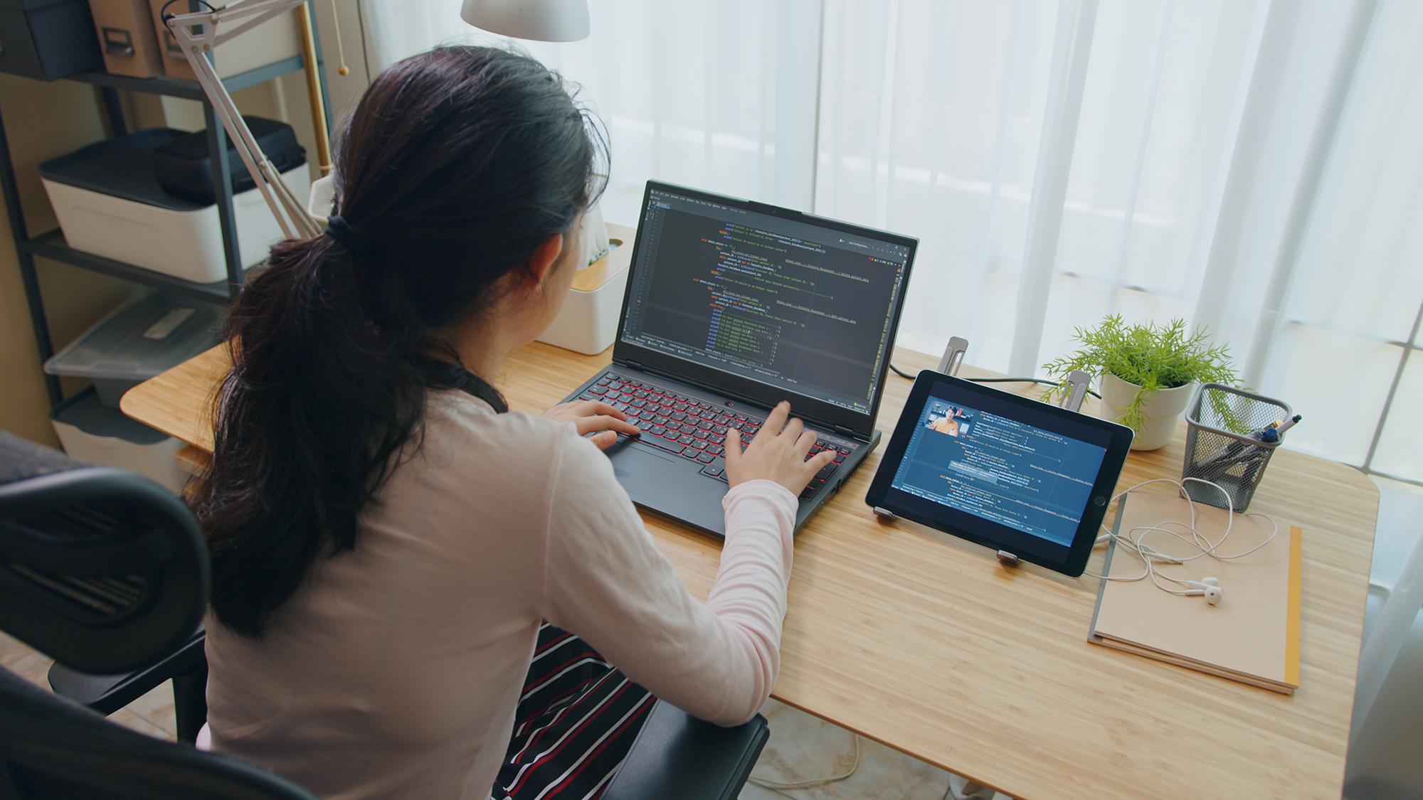 Woman working on computer code on a laptop