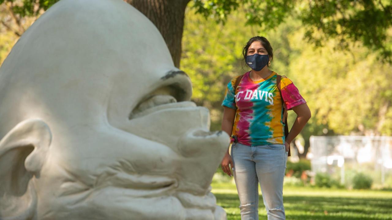 UC Davis student in mask next to Mrak Egghead
