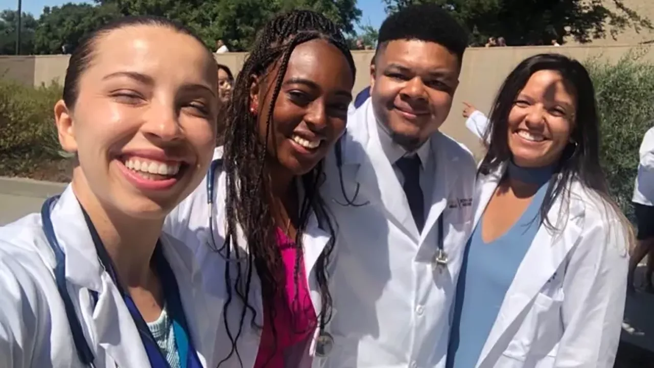 UC Davis Health Professions Post-bac grads Andre Brown, Matileen Cranick, Kayla Hall, Rachel Becker take a selfie in their white coat