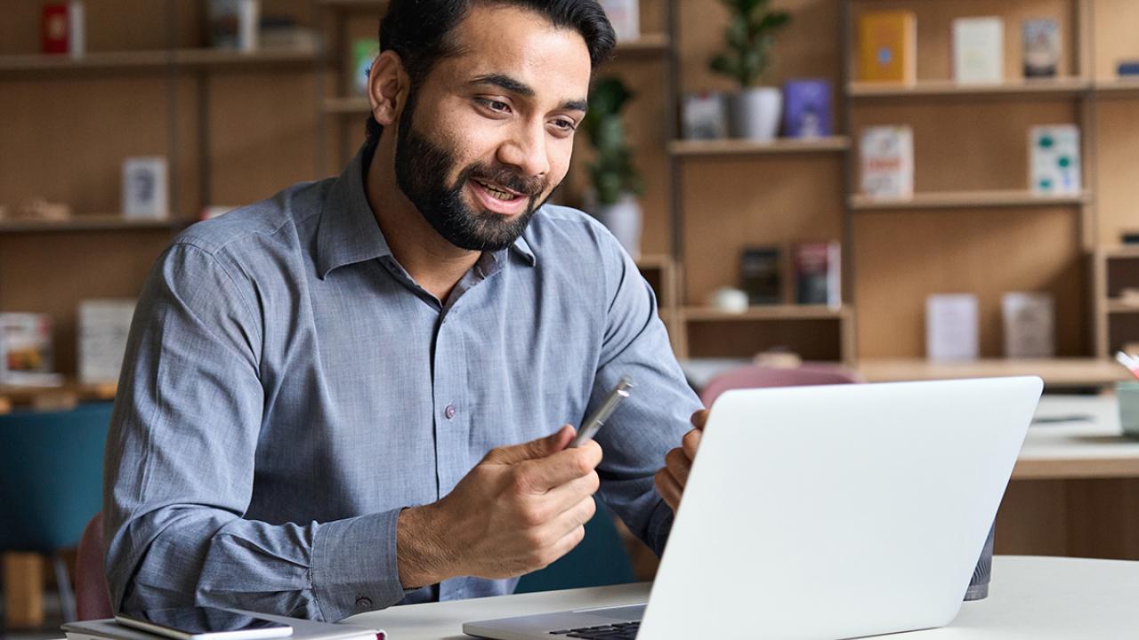 Student sitting at computer at home engaged in online learning or training