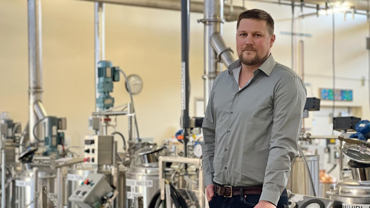 Jon Hughes next to brewing equipment