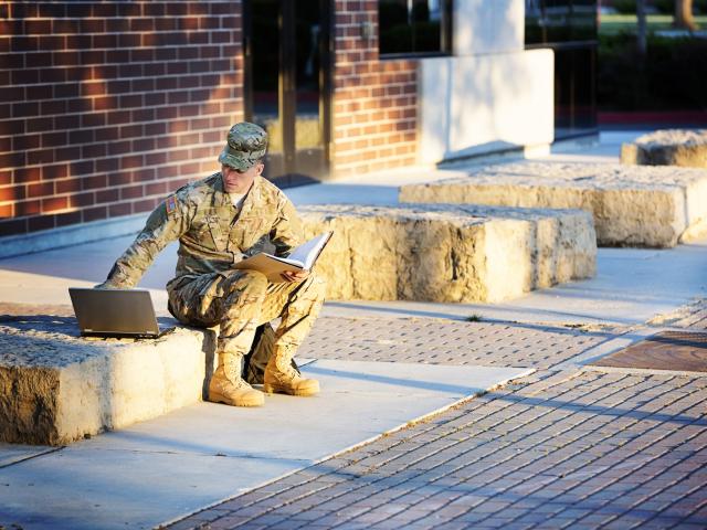 Member of Military working on laptop