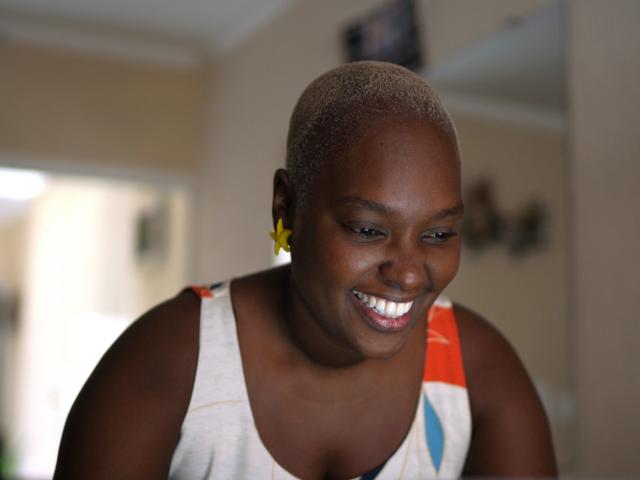 Smiling woman works at a laptop at home. 