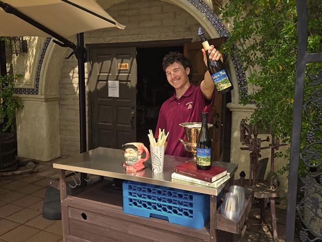 UC Davis Winemaking Certificate student Matthew Tibbetts holds up a bottle of wine at his family's winery