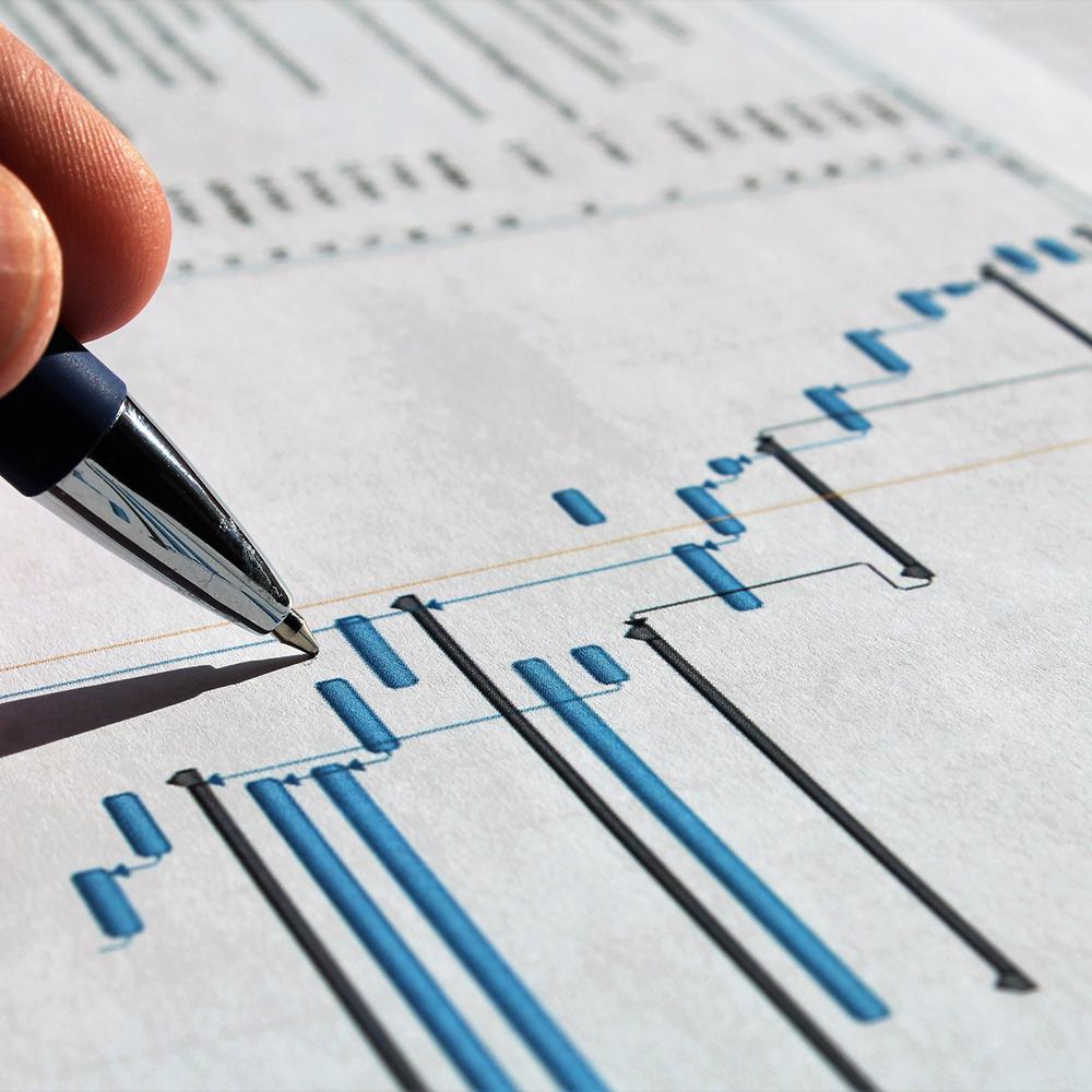 person writing on gantt chart