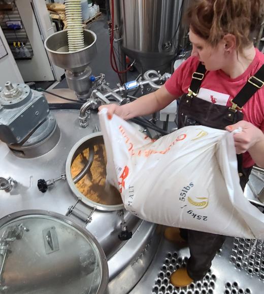 Jae Vanderwerf working in the brewery, adding malt