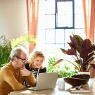 happy senior couple on computer at home