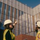 construction professionals outside pointing and looking up at a building