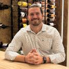 UC Davis online winemaking program grad poses for a photo in a winery