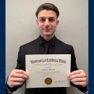 Carlton Brown poses with his Paralegal Certificate of Completion from UC Davis CPE