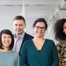 a group of people of varied races, genders and ages standing in a line