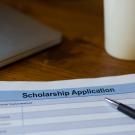 scholarship application, pen and coffee mug on desk