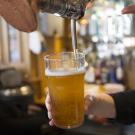 bar tender filling glass with beer at tap